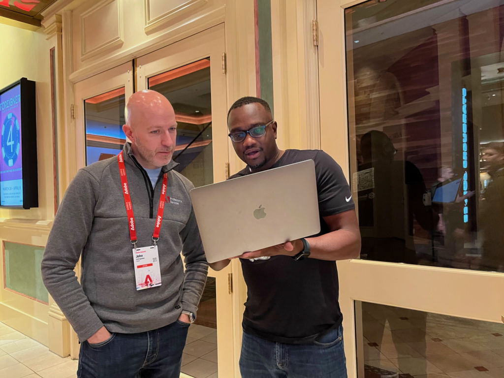 Sentinel Insights CEO Maigari Jinkiri giving a data quality product demo at Adobe Summit to an Adobe Summit attendee. 