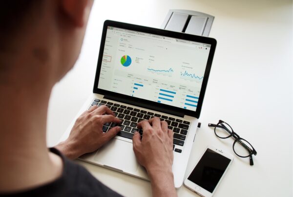 Photo of a person looking at a computer screen that displays charts and graphs, presumably of digital data analytics